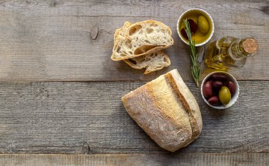 Zeytinyağlı taze İtalyan ciabatta ekmeği. Yukarıya bak, boşluğu kopyala, eski ahşap masa.