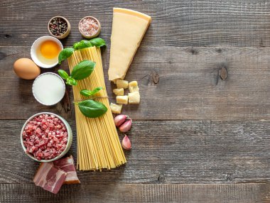 Geleneksel İtalyan Carbonara makarnası için taze ham malzemeler. Üst görünüm, tahta tablo, tarif veya metin için kopyalama alanı