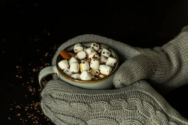 Hände in Fäustlingen halten eine Tasse heißen Kakao oder Schokolade mit Marshmallow. — Stockfoto