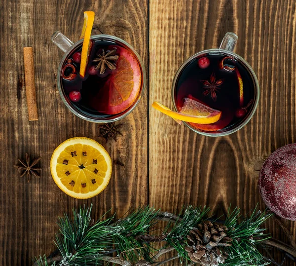 Вино с апельсинами и специями на деревянном столе — стоковое фото
