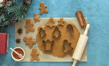 Noel kurabiyeleri için yuvarlanmış hamurla ahşap masada tatil süslemeleri.