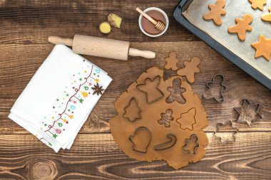 Noel kurabiyeleri için yuvarlanmış hamurla ahşap masada tatil süslemeleri.