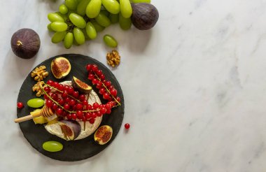 Ballı, meyveli, fındıklı ve mermer kaplamalı peynirli fırın peyniri. Üst görünüm, alanı kopyala.