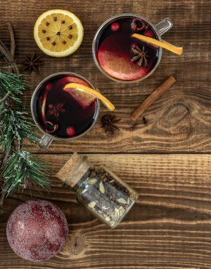 İki bardak portakallı sıcak şarap ve Noel süslemeli baharatlar. Dikey yönelim.