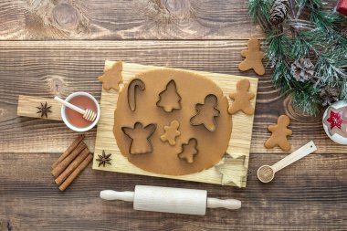 Noel kurabiyeleri için yuvarlanmış hamurla ahşap masada tatil süslemeleri.