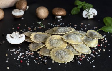 Taze çiğ İtalyan usulü makarna ravioli veya mantarlı tortelli, pesto ve ricotta. Ev yapımı yemek, vejetaryen tarifi..