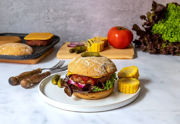 Hamburgerin ötesinde, proteinin geleceği. Bitkilerden yapılmış, soya yok, glüten yok. Vejetaryen peyniri, soğan, mısır ve turşu ile servis edilir.. 