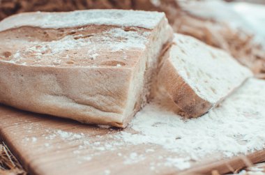 Tahtadaki buğday ekmeğine karşı altın buğday samanı. Doğal altyapı. Ekmek, kağıt ve ahşap tahta üzerinde. Buğday unuyla yazdırın. Boşluğu kopyala