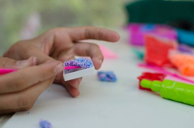 Renkli plastikle çocuk elleri. Çocuk oyun oynuyor ve oyun testinden figürler yaratıyor. Renkli killi çocuk elleri. Çocuk oyun oynuyor ve oyun hamurundan serseriler yaratıyor. Kil kalıbı yapan kız. Ev yapımı kil.