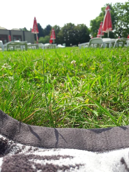 在游泳池边放松 草坪和毛巾 — 图库照片