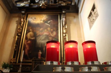 Kilisenin sunağında kırmızı mumlar.