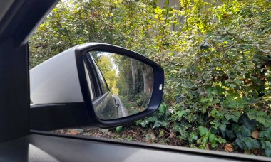 Dikiz aynası kırsalda araba sürüyor.