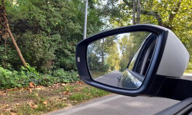 Dikiz aynası kırsalda araba sürüyor.