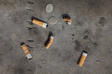 Çöpe atılmış sigara izmaritleri ve çiğnenmiş sakızlar.