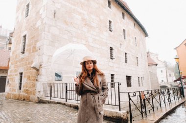 Annecy 'de şeffaf şemsiyeli palto ve şapkalı güzel romantik bir kız. Fransa. Fransa 'daki şapkalı kız..