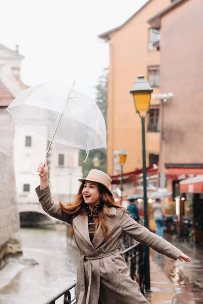 在Annecy 一个穿着外套 头戴帽子 头戴透明雨伞的漂亮的浪漫女孩 在法国戴帽子的女孩 — 图库照片