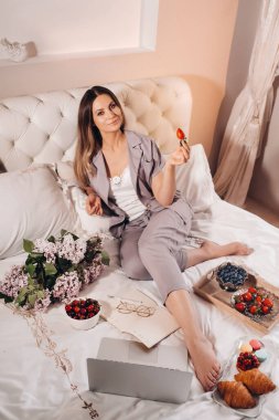 Bir kız akşamları yatakta oturup dizüstü bilgisayar izler ve çilek yer. Yatmadan önce tatlı yer..