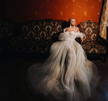 Beyaz bir gelinlikle yerde yatan güzel bir gelinin portresi. Yeşil çimlerin üzerinde zarif bir gelinin fotoğrafı. Gelinin üst fotoğrafı.