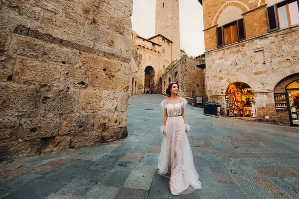 San Gimignanoa 도시에서 드레스를 소녀가 이탈리아 투스카니에서 걸어서 도시를 돌아다닌다 — 스톡 사진