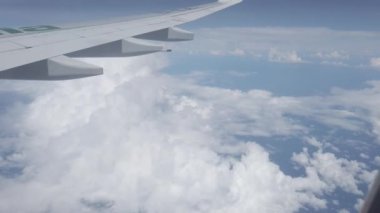 Uçak uçuşu. Bulutların üzerinde uçan bir uçağın kanadı. Uçak penceresinden bak. Uçak. Hava yoluyla seyahat et..