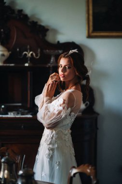 Bir düğünde, İtalya 'da bir villada iç çamaşırlı ve beyaz cüppeli bir gelin. Gelinin Tuscany.boudoir' da çekilmiş bir fotoğrafı.