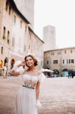 San Gimignano 'nun eski kasabasında beyaz elbiseli bir gelin. İtalya' da bir kız dolaşıyor. Toskana 'da.