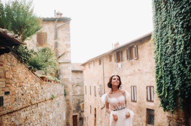 San Gimignano 'nun eski kasabasında beyaz elbiseli bir gelin. İtalya' da bir kız dolaşıyor. Toskana 'da.