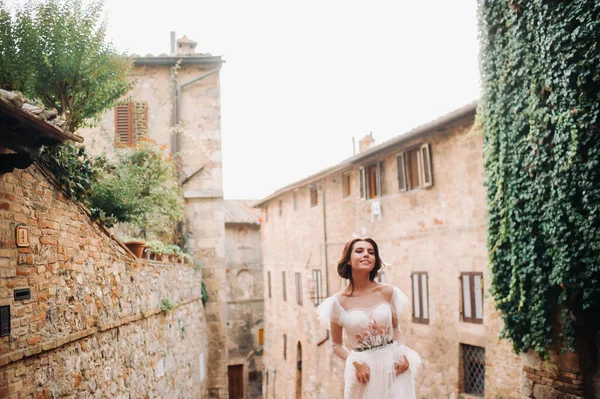San Gimignano 'nun eski kasabasında beyaz elbiseli bir gelin. İtalya' da bir kız dolaşıyor. Toskana 'da.