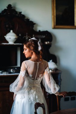 Bir düğünde, İtalya 'da bir villada iç çamaşırlı ve beyaz cüppeli bir gelin. Gelinin Tuscany.boudoir' da çekilmiş bir fotoğrafı..