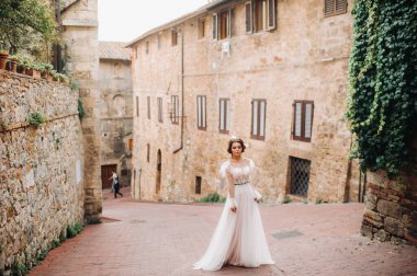San Gimignano 'nun eski kasabasında beyaz elbiseli bir gelin. İtalya' da bir kız dolaşıyor. Toskana 'da..