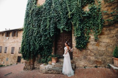 San Gimignano 'nun eski kasabasında beyaz elbiseli bir gelin. İtalya' da bir kız dolaşıyor. Toskana 'da.