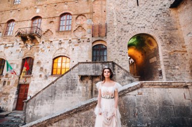 San Gimignano 'nun eski kasabasında beyaz elbiseli bir gelin. İtalya' da bir kız dolaşıyor. Toskana 'da.