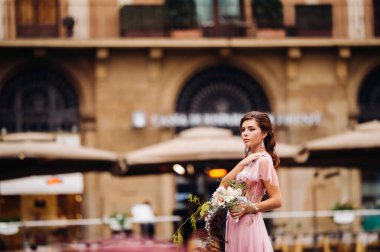 Genç ve güzel bir gelin, İtalya 'daki eski Floransa şehrinin merkezinde duruyor. Tuscany 'de güzel pembe elbiseli bir gelin. İtalya' da..