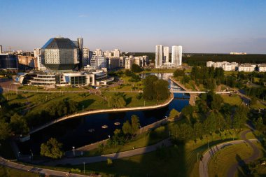 Günbatımında Belarus Cumhuriyeti 'nin başkenti Minsk' te parkı olan yeni bir mahalle ve ulusal kütüphane manzarası..