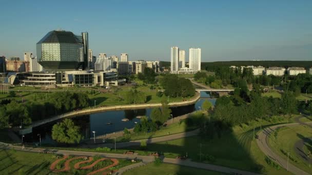 Blick von oben auf die Nationalbibliothek und ein neues Viertel mit einem Park in Minsk bei Sonnenuntergang. Weißrussland, öffentliches Gebäude — Stockvideo