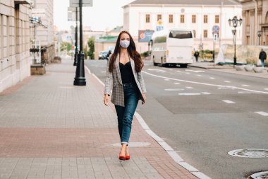 Evde rahatlamış bir kız kahve içiyor ve film seyrediyor. Kız rahat bir şekilde kanepede oturuyor ve kahve içiyor..