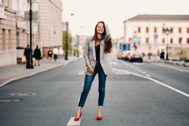 Evde rahatlamış bir kız kahve içiyor ve film seyrediyor. Kız rahat bir şekilde kanepede oturuyor ve kahve içiyor..