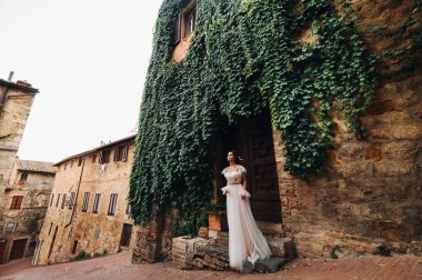 San Gimignano 'nun eski kasabasında beyaz elbiseli bir gelin. İtalya' da bir kız dolaşıyor. Toskana 'da.