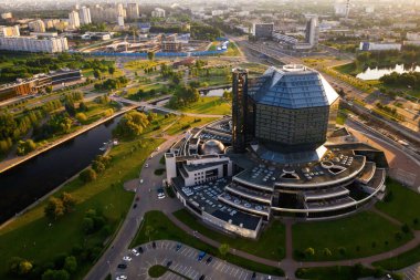 Günbatımında Belarus Cumhuriyeti 'nin başkenti Minsk' te parkı olan yeni bir mahalle ve ulusal kütüphane manzarası..