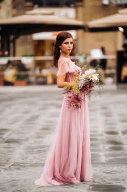Genç ve güzel bir gelin, İtalya 'daki eski Floransa şehrinin merkezinde duruyor. Tuscany 'de güzel pembe elbiseli bir gelin. İtalya' da..