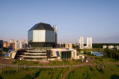 Günbatımında Belarus Cumhuriyeti 'nin başkenti Minsk' te parkı olan yeni bir mahalle ve ulusal kütüphane manzarası..