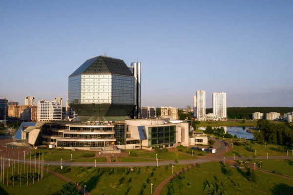 Günbatımında Belarus Cumhuriyeti 'nin başkenti Minsk' te parkı olan yeni bir mahalle ve ulusal kütüphane manzarası..