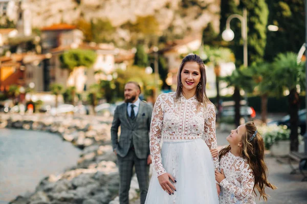 Italy, Lake Garda. Beautiful family on the shores of lake Garda in Italy at the foot of the Alps. Father, mother and daughter in Italy.