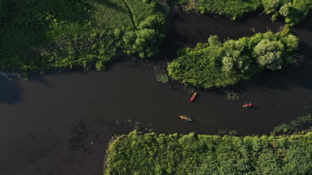 Øverste utsikt over Svisloch-elvens kajakker som flyter på elven i Loshitsky Park ved solnedgang. Folk slapper av ved elven på kajakkpadlere.. – stockvideo