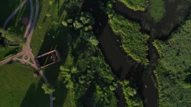 Svisloch nehri ve bisiklet yolu olan parkın üst manzarası. Günbatımında Loshitsky Parkı 'nda nehirde yüzen kayakçılar. İnsanlar nehirde kano ve bisiklet sürerken rahatlar.