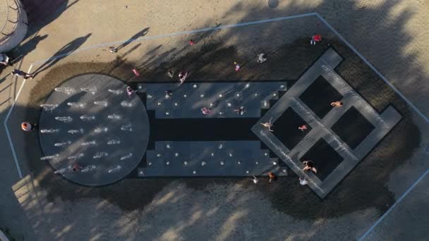 Kinder spielen im Stadtbrunnen im Sommer in der Hitze in Minsk. Die Menschen ruhen sich in der Nähe des Stadtbrunnens aus und entfernen die Hitze. Weißrussland — Stockvideo