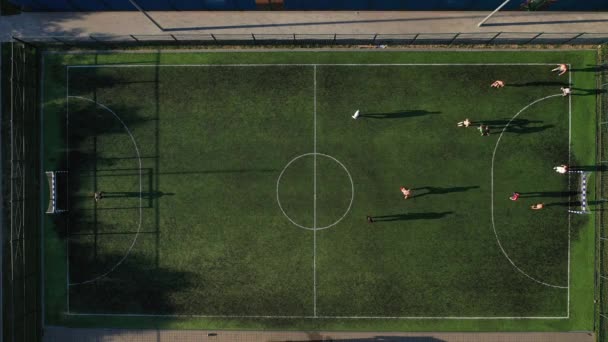 Vue de dessus d'un terrain de football sportif avec des personnes jouant au soccer.a petit terrain de football dans la rue dans le quartier Serebryanka. — Video