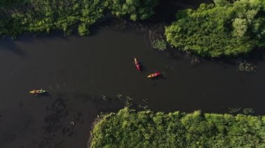 Gün batımında Loshitsky Parkı 'ndaki nehirde yüzen Svisloch nehir kayakçılarının üst manzarası. İnsanlar kano üzerinde nehirde yüzerken rahatlar. Belarus' un güzel doğası..
