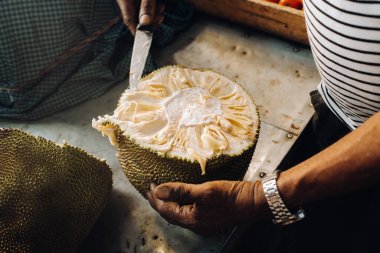 Satıcı turistler için sulu, olgun bir meyve keser. Port Louis, Mauritius kentsel pazarı