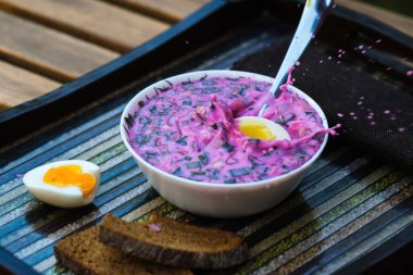 Süslü tepside yumurta ve ekmek ile soğuk pancar çorbası. Alışılmadık bir tepside kholodnik çorbası. Yiyecek..